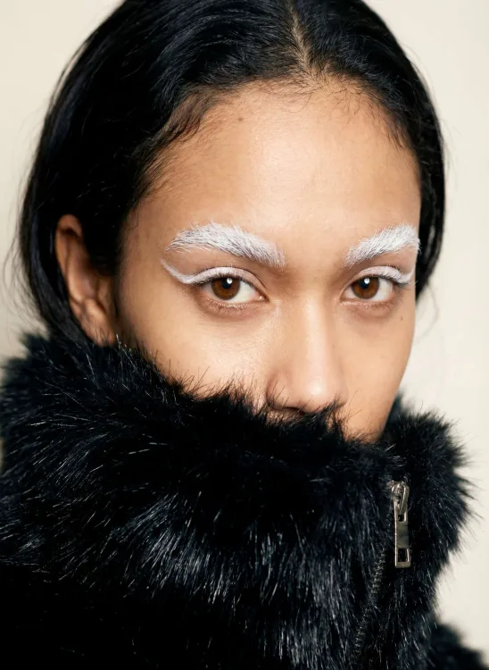Portrait with bleached eyebrows wrapped in black fur