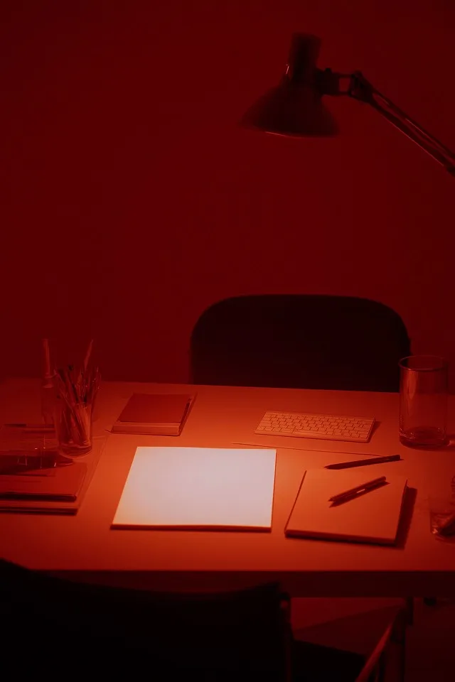 Study desk with papers under deep red light
