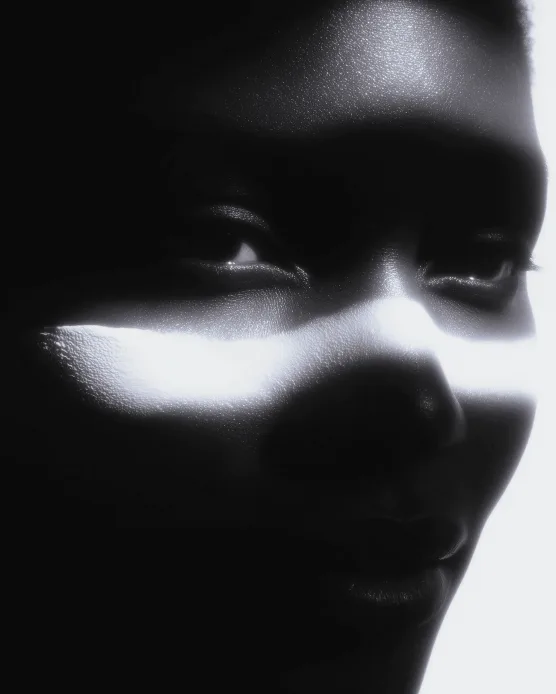 Black and white portrait with a stripe of white paint across the face